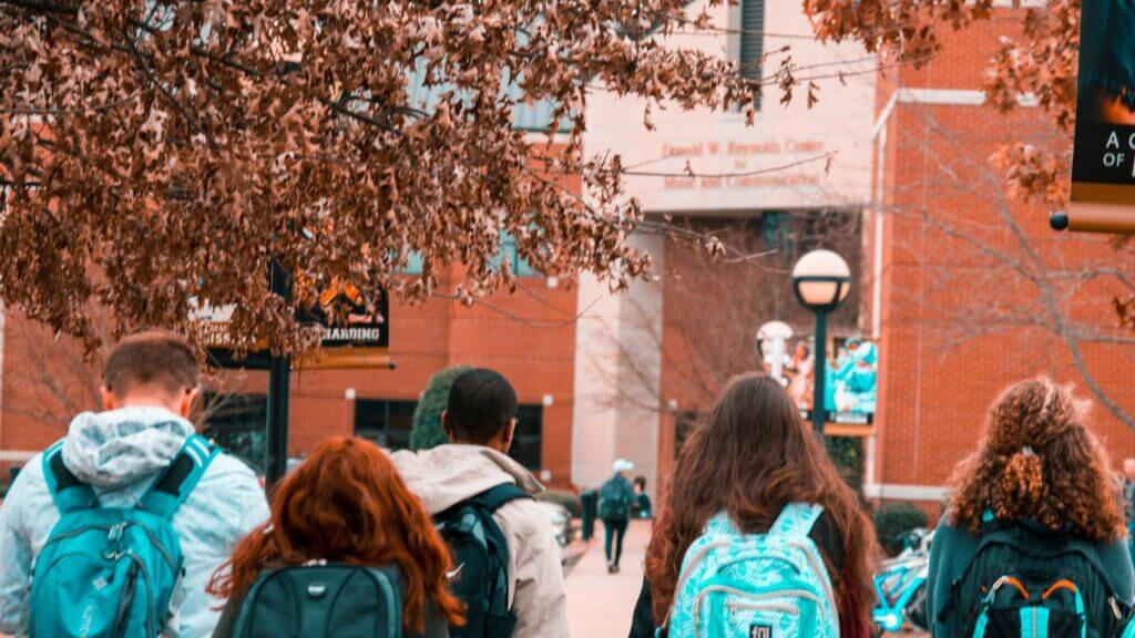Students walking on university campus path.