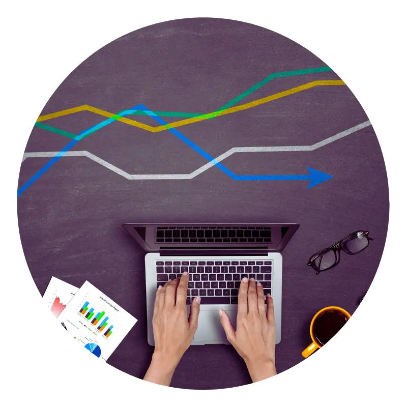 Person typing on laptop with business charts.